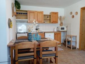 una cocina con mesa de madera y sillas y una cocina con en Apartments Ľubka en Zuberec