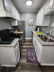 a kitchen with white cabinets and a stainless steel refrigerator at Blue Shark *G13* @ Midtown Central 1BR King Apartment in Houston