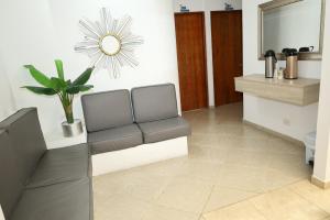 uma sala de espera com um banco e um espelho em Ayenda Torre 2 em Apartadó