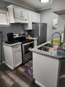 een keuken met een wastafel en een fornuis top oven bij Blue Shark *G13* @ Midtown Central 1BR King Apartment in Houston