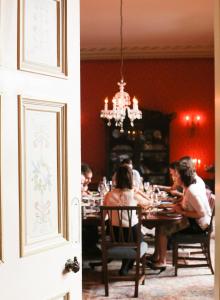 a group of people sitting at a dining room table at Ballyvolane House in Fermoy