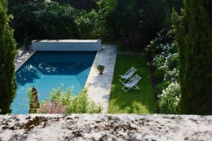 a swimming pool in a garden with two lawn chairs at Le Gaimont Maison d'Hôtes Vouvray in Vouvray