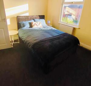 una camera da letto con un grande letto e una finestra di The Smart Stay - sleeps 5 Wigan central location a Wigan