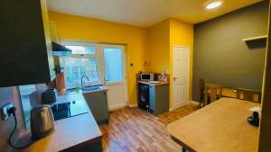 una cucina con pareti gialle e piano di lavoro di The Smart Stay - sleeps 5 Wigan central location a Wigan