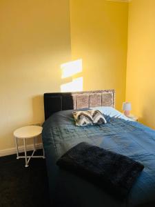 a cat laying on a bed in a bedroom at The Smart Stay - sleeps 5 Wigan central location in Wigan