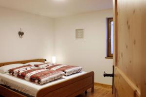 Un dormitorio con una cama con una manta encima. en CASA DOLOMIA - Agenzia Dolomiti Affitti, en Cavalese