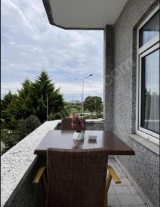 uma mesa e cadeiras numa varanda com uma janela em GDL DOKUZ OTEL em Kalkanlı