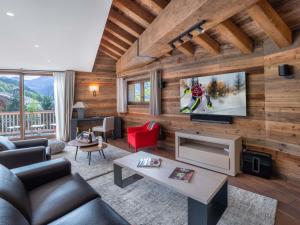 ein Wohnzimmer mit Holzwänden und einem Fernseher in der Unterkunft Chalet moderne lumineux proche pistes - 12 pers, 5 ch, parking, wifi, ménage inclus - FR-1-566-43 in Les Allues