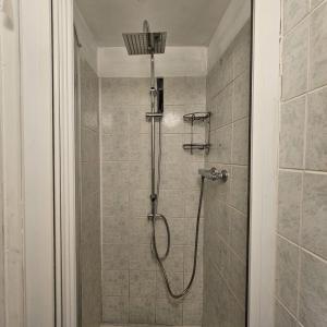 a shower with a shower head in a bathroom at Victoria Guest House in Stoke on Trent