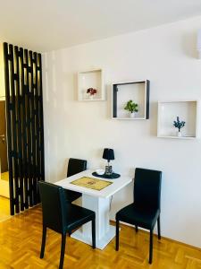 a white table with two chairs and a lamp on it at Apartman EMA in Požarevac +5 photos