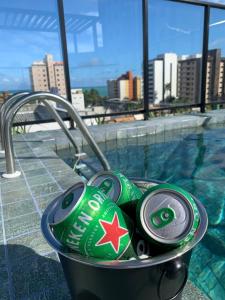 un cubo lleno de latas de soda junto a una piscina en lindo apt a 200 m da praia em Joao pessoa en Cabedelo