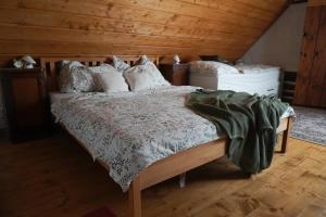 1 dormitorio con 1 cama con techo de madera en Chalupa na Valech, en Krompach