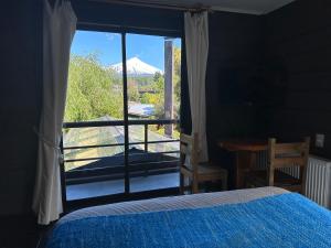 a bedroom with a bed and a view of a mountain at Newen B&B in Pucón