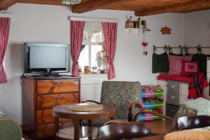 sala de estar con TV, mesa y sillas en Chalupa na Valech, en Krompach