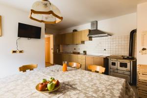 una cocina con una mesa con un bol de fruta. en Bergreen Apartments, en Ossana