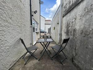 uma mesa e duas cadeiras sentadas num pátio em Dream Weaver Apartment em Swansea