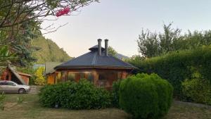 een klein houten huis met een zwart dak bij Las Bandurrias de Llifen in llifen
