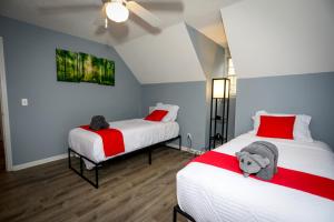 um quarto com 2 camas com lençóis vermelhos e brancos em Escape to Serenity Luxurious 4Bedroom 3Bath Oasis with Private Pool Near Fort Jackson em Columbia
