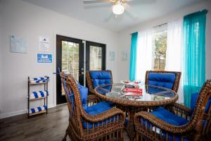 a dining room with a glass table and wicker chairs at Tranquil Retreat, 4 Bedroom, 3 Bath Oasis with Private Pool Near Fort Jackson in Columbia
