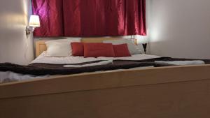 uma cama com duas almofadas vermelhas em cima em Apartment Reki em Rovaniemi