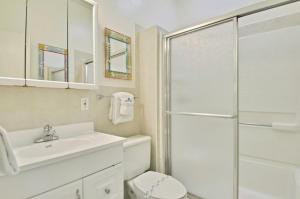 y baño blanco con lavabo y ducha. en Little Bay Prime, en Islamorada