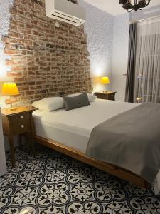 um quarto com uma cama e uma parede de tijolos em Villa Veria em Cesme