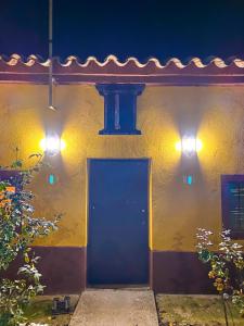 a yellow building with a blue door and two lights at La Casita Encendida in Villamayor de Campos