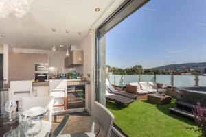 a kitchen and living room with a balcony with green grass at Stylish Penthouse Apartment With Hot Tub in Bath