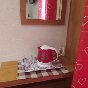 a tea kettle and glasses on a table at Pokoik Walentynka in Gniezno