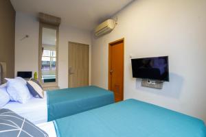 a hotel room with two beds and a flat screen tv at Kelowna Mangga Besar by AbdiHome in Jakarta