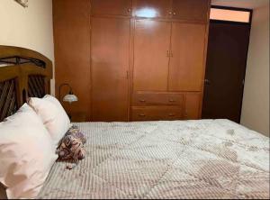 - une chambre avec un lit et une tête de lit en bois dans l'établissement Alojamiento a una cuadra de la plaza de armas, à Puno