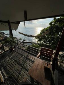 stół i krzesło na balkonie z widokiem na ocean w obiekcie Sea Lulaby w mieście Ko Phangan