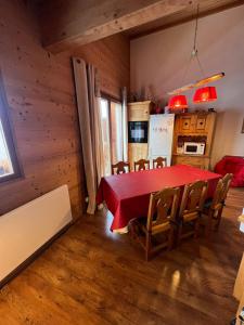 cocina y comedor con mesa roja y sillas en DUPLEX 50 m2 aux pieds des pistes les saisies hauteluce et contamines montjoie savoie 6 à 8 personnes 1 chambre et un coin nuit, en Hauteluce