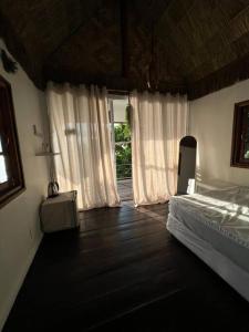 um quarto com uma cama e uma grande janela em Sea Lulaby em Ko Phangan