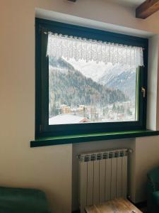 a window with a view of a snowy mountain at Casa Francesca in Ponte di Legno