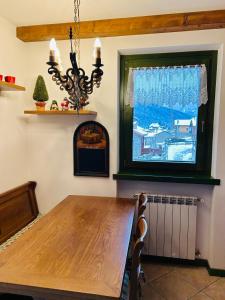 a dining room with a wooden table and a window at Casa Francesca in Ponte di Legno +7 photos