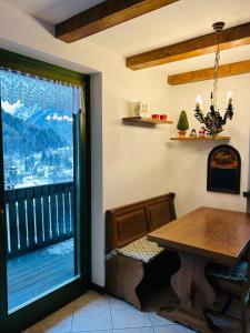 a dining room with a table and a large window at Casa Francesca in Ponte di Legno +7 photos