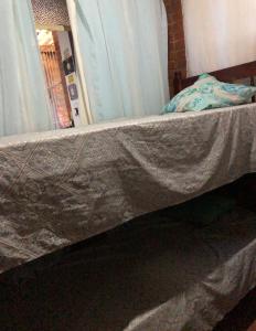 a bed with a sheet on top of it at Hostel dos Reis in Angra dos Reis