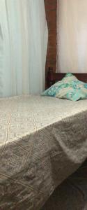 an unmade bed in a bedroom with a curtain at Hostel dos Reis in Angra dos Reis