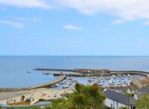 a view of a beach with boats in the water at Lovely well equipped apartment - 2 bedroom, sleeps 4, sundeck, 8 min river walk to beach and town, FREE parking permit ! in Lyme Regis