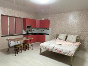 um quarto com armários vermelhos, uma cama e uma mesa em Днестровский em Carcóvia