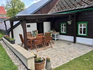 un patio con sillas y una mesa frente a una casa en Chalupa na Valech, en Krompach