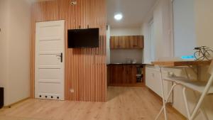 eine Küche mit Tür und TV drauf in der Unterkunft Apartament z rowerami in Misdroy