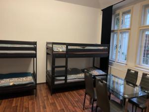 a room with three bunk beds and a table and chairs at Hostel Moon in Prague