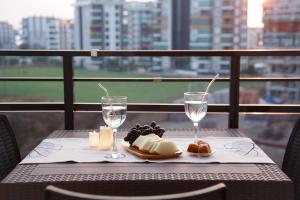a table with cheese and wine glasses on a balcony at ArtLife apartments (grafic arts) in Alanya