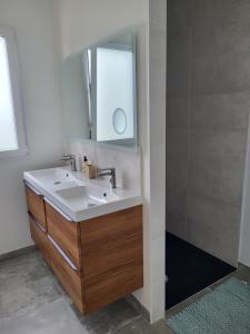uma casa de banho com um lavatório e um espelho em Villa Lou Sanaé - Bord de mer - Spa, paddle, Kayak - Classé 4 étoiles em Santec