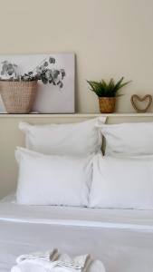 a bed with white pillows and a shelf with plants at Andas cabin CITQ#313550 in Lac-Superieur