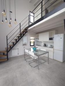 a kitchen with a glass table and a staircase at Los Miradores del Terrado in Las Grutas