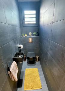 Villa Tilanga في سانت فرانسوا: حمام مع مغسلة وسجادة صفراء