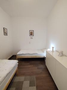 een witte kamer met 2 bedden en een bureau bij Schwert Ferienwohnung Monteurwohnung Verden in Verden